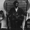 untitled (Huey P. Newton on a wicker peacock chair)