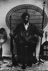 untitled (Huey P. Newton on a wicker peacock chair)