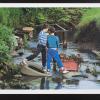 untitled (two boys standing on tires in a garbage-filled body of water)